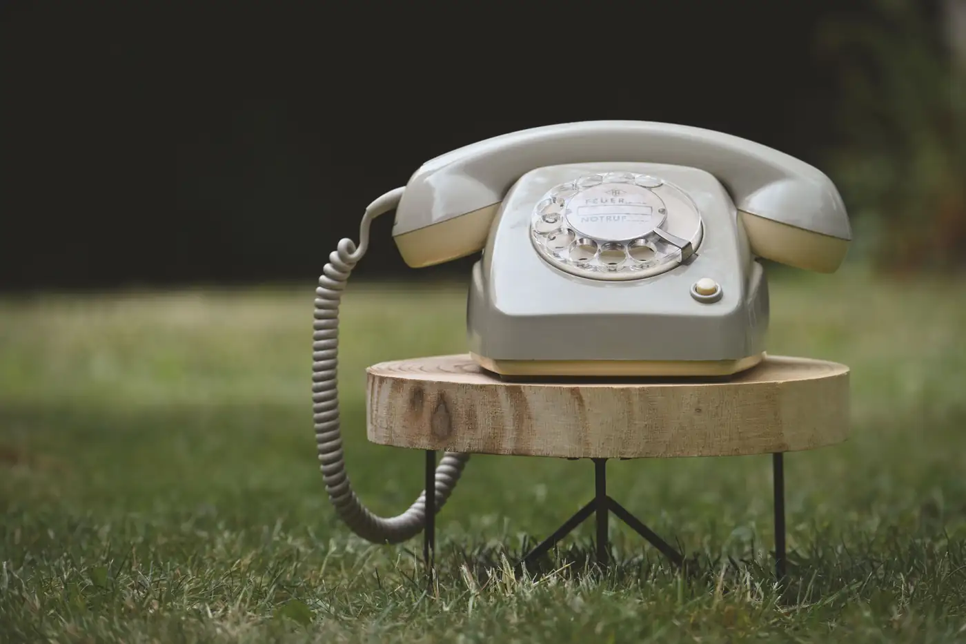 Téléphone vintage posé sur un tabouret en bois dans l’herbe, mariage champêtre