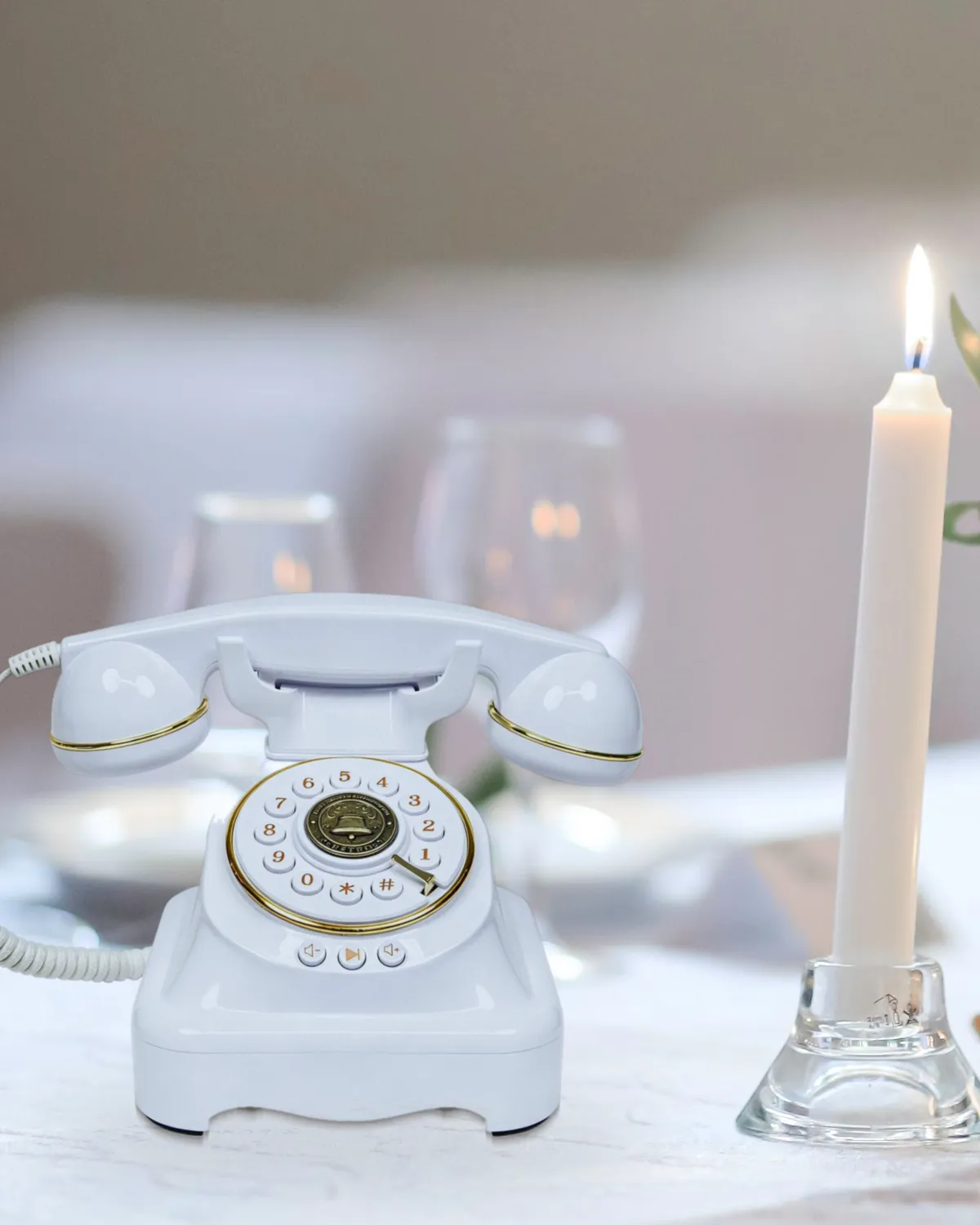 Suzanne, téléphone livre d’or blanc, posé sur une table de réception entre une bougie et un bouquet